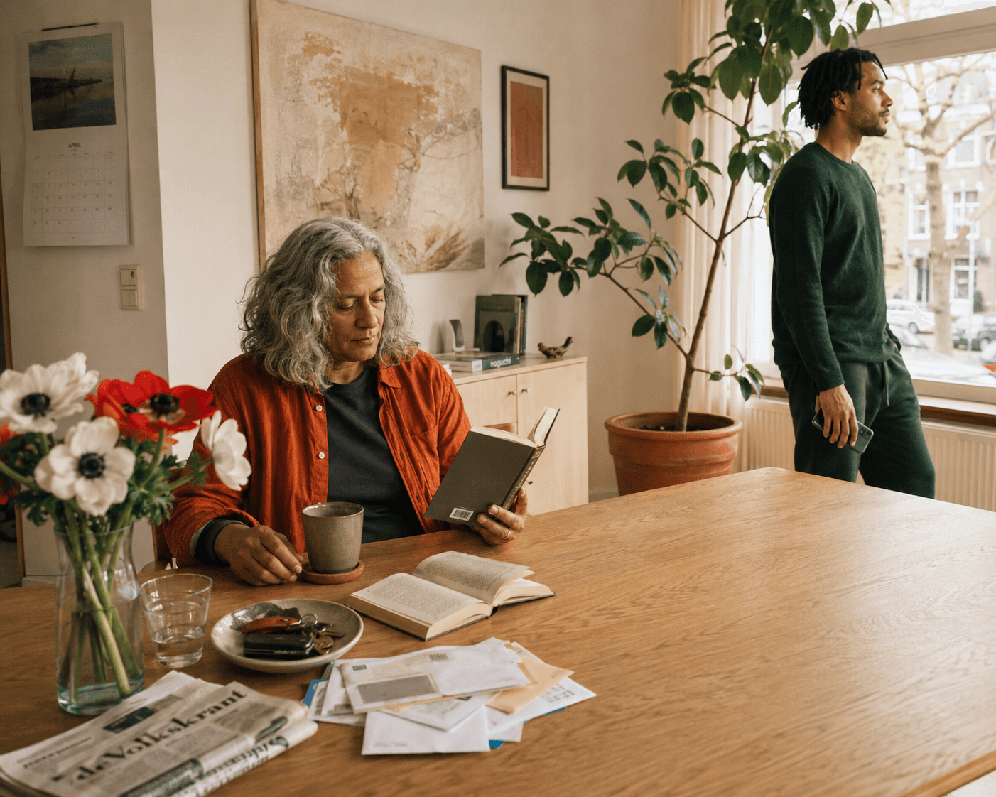 Two generations sit together at a table in a light kitchen